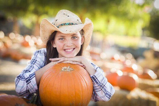 Portrait of Preteen Girl Wearing Cowboy Hat Playing at the Pumpk